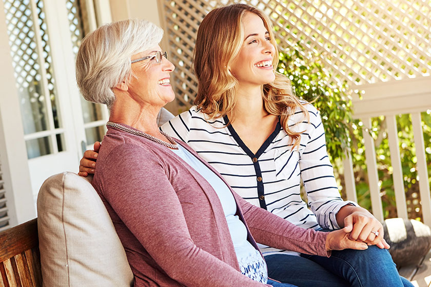 a senior woman sitting outside with her adult daughter