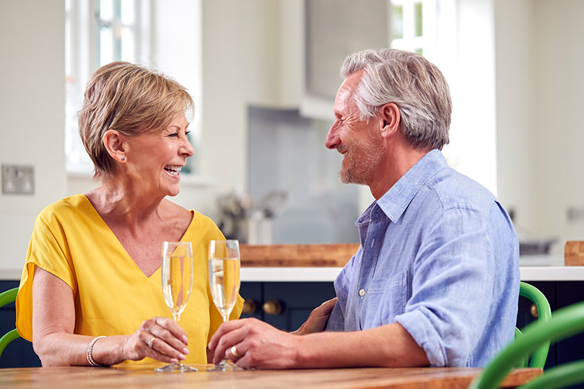 Retired Couple Celebrating With Glass Of Champagne