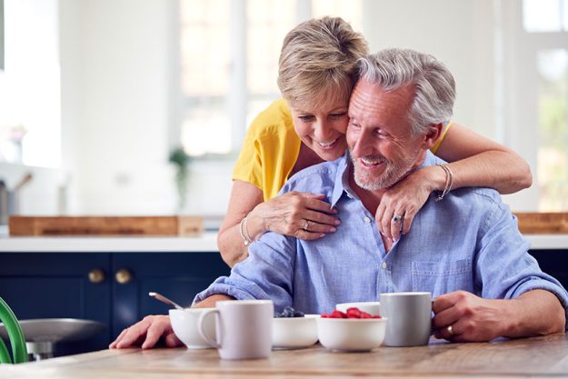 Loving Retired senior Couple Sitting Around Table At Home Having Healthy Breakfast Together Loving Retired senior Couple Sitting Around Table At Home Having Healthy Breakfast Together