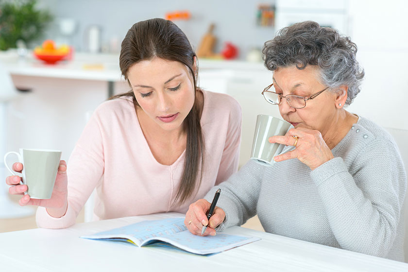 Senior woman and her daughter at the kitchen table