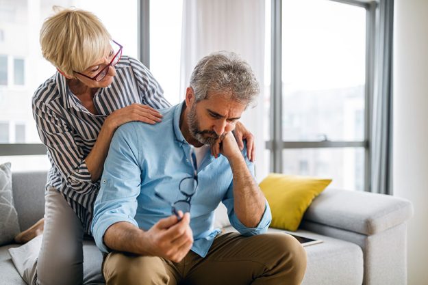 Senior woman comforting elderly man