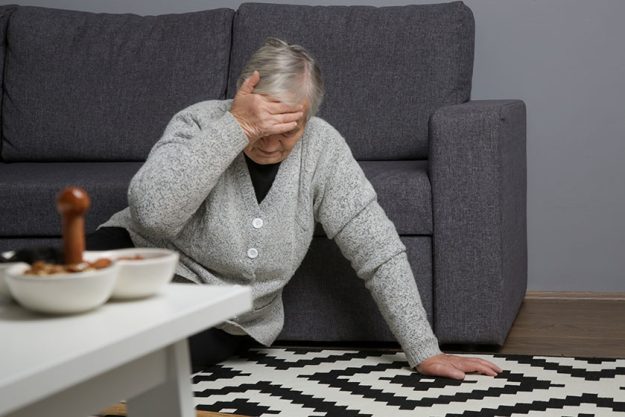 Senior woman lying on the floor in living room