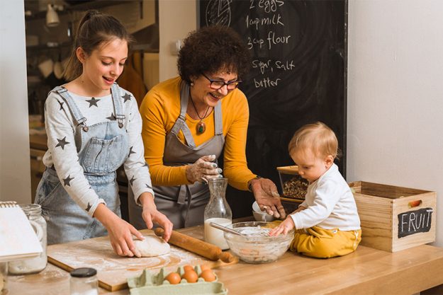 Senior woman with her grandchildren baking together in kitchen Senior woman with her grandchildren baking together in kitchen