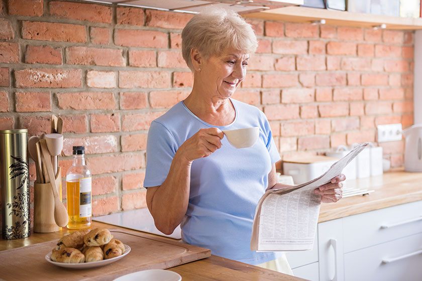 Woman drinking tea and reading paper