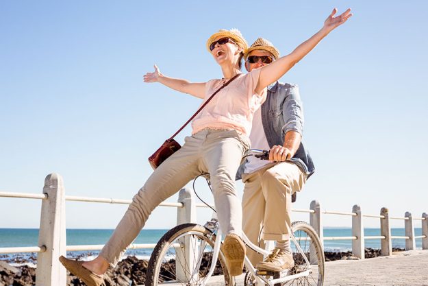 Happy casual couple going for a bike ride