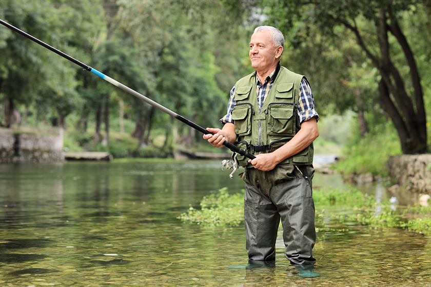 Mature fisherman fishing in river Mature fisherman fishing in river