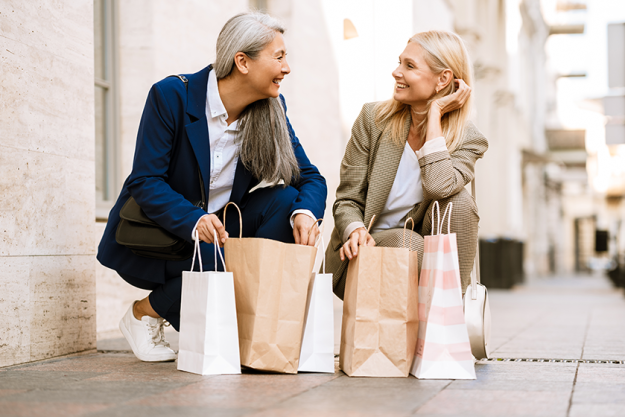 mature multiracial women talking looking shopping bags