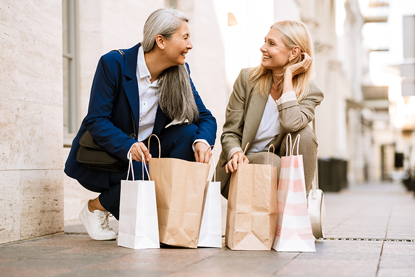 mature multiracial women talking looking shopping bags