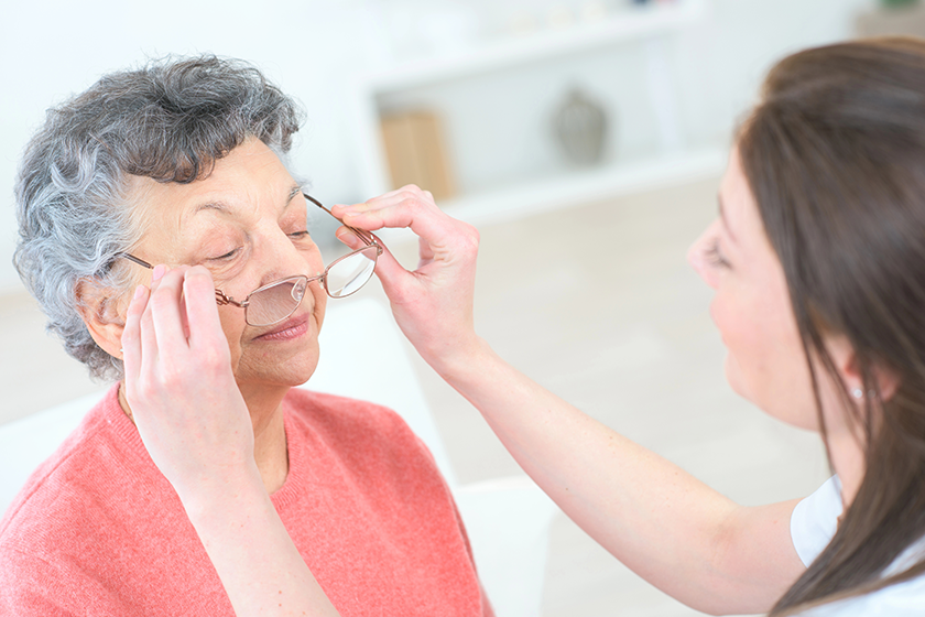 old woman at the oculist tries pair of glasses