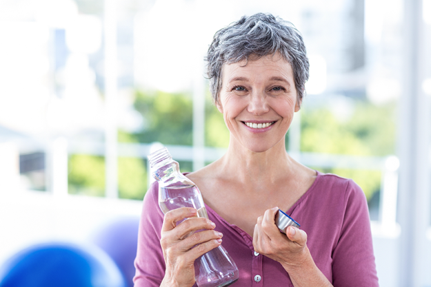 portrait of happy mature woman with water bottle