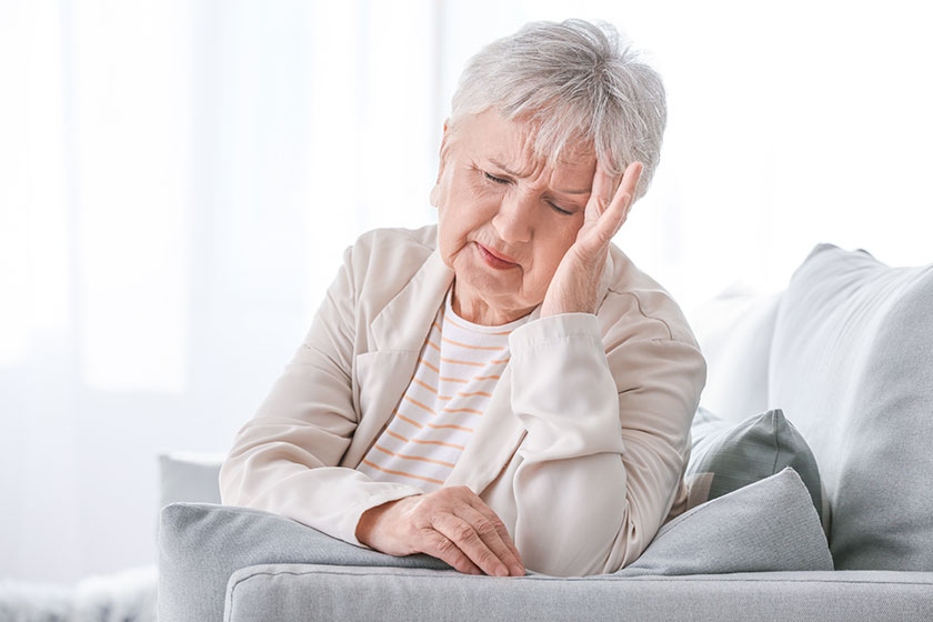 Senior woman suffering from headache at home