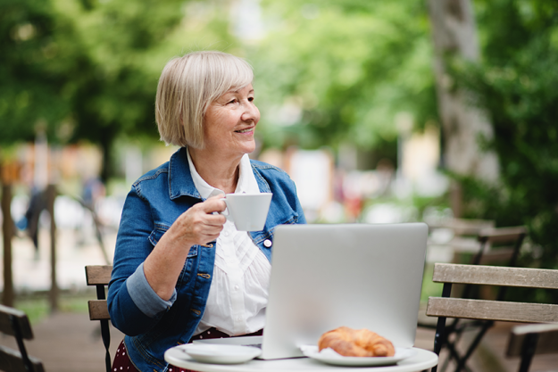 senior woman with coffee sitting outdoors