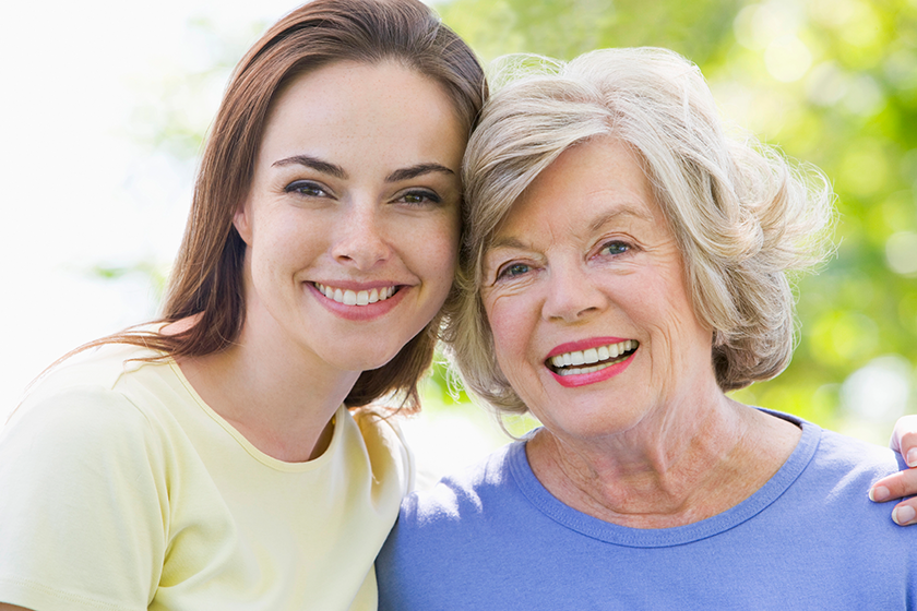 two women outdoors embracing and smiling