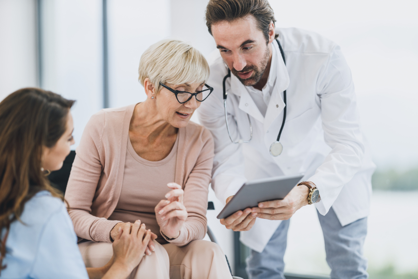 Doctor And Nurse Talking With Their Senior Female Patient At Nursing Home