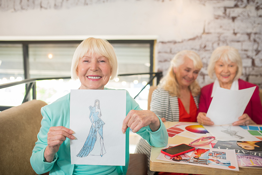 A blonde woman in a blue suit showing a sketch