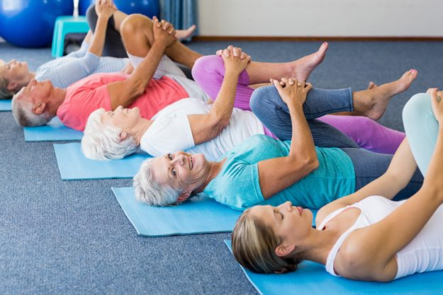 Instructor performing yoga with seniors