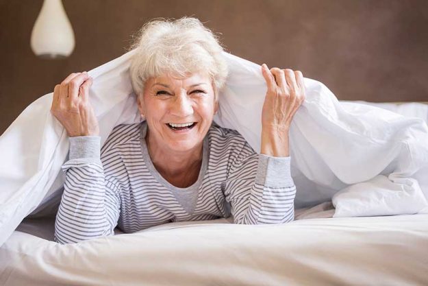 Mature woman smiling in bed