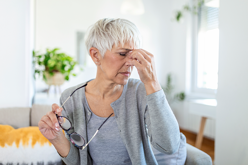 Senior woman in glasses rubs her eyes Senior woman in glasses rubs her eyes