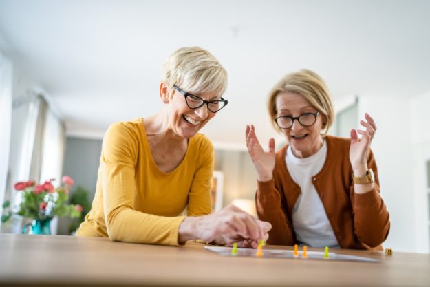 two senior women friends or sisters play leisure board game at h two senior women friends or sisters play leisure board game at h