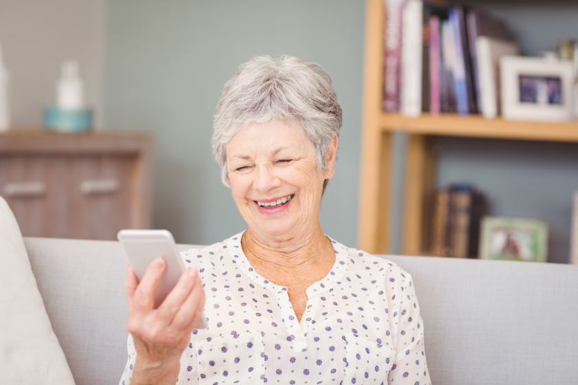 Senior woman holding mobile phone at home Senior woman holding mobile phone at home