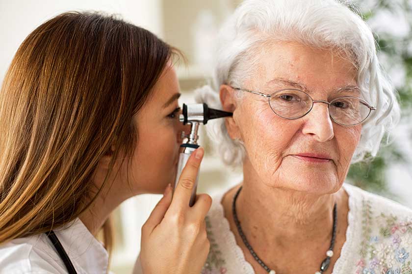 Young beautiful doctor holding otoscope