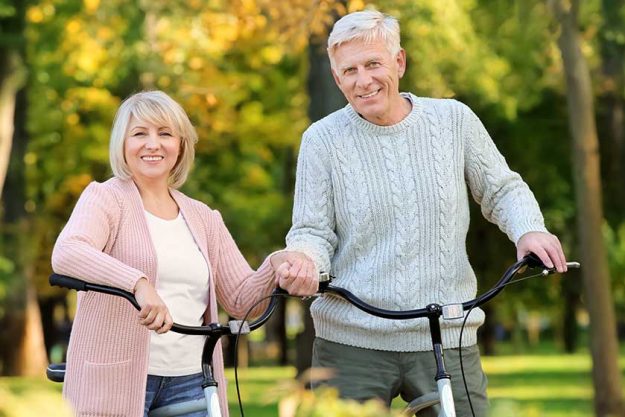 Cute elderly couple with bicycles in autumn park Cute elderly couple with bicycles in autumn park