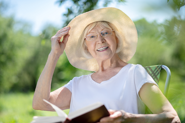 Joyful woman reading a book in the garden