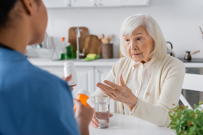 Retired woman with grey hair asking about medication
