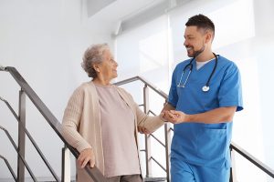 Doctor helping senior patient in modern hospital