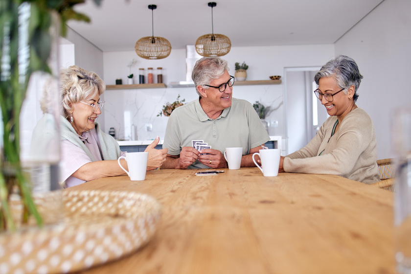 Playing cards, bonding and senior friends with coffee to relax in retirement with a game in a home. Talking, together and a senior man with women or people at a table for fun, break or happiness 16 Ways Senior Active Living In Inez, TX Meets Your Social Needs