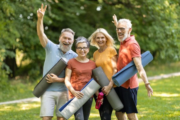 Active Lifestyle On Retirement. Sporty Senior People With Joga Mats Posing Outdoors Boosting Your Overall Wellness By Retiring In A Neighborhood You'll Love In Independent Living Communities In Pantego, TX