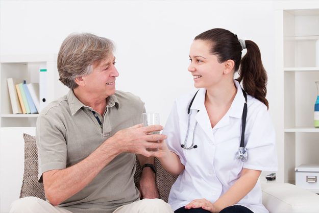 Doctor offering glass of water to patient