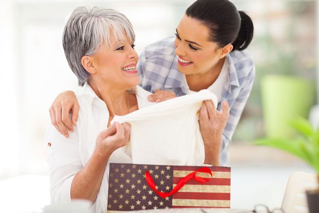 Excited middle aged mother looking at her gift Excited middle aged mother looking at her gift