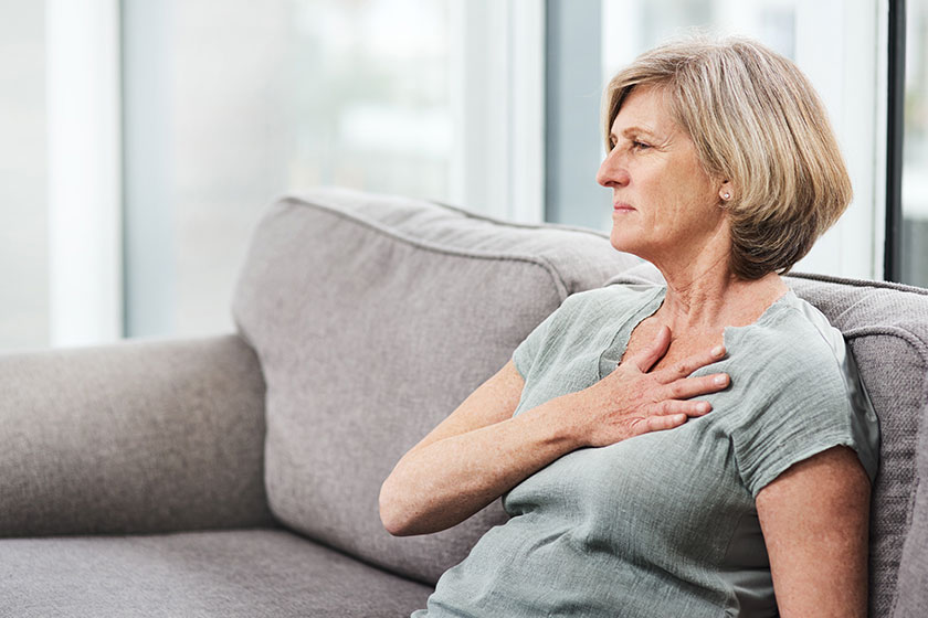 heart attack chest senior woman pain her home living room