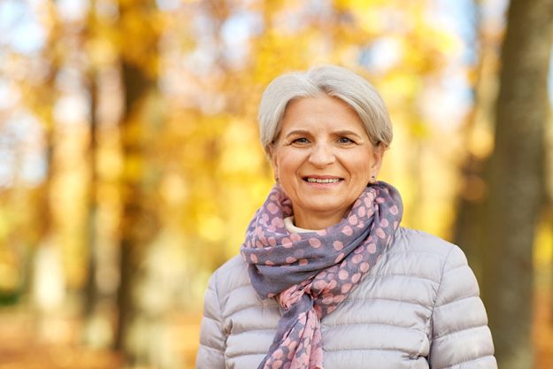 portrait of happy senior woman at autumn park