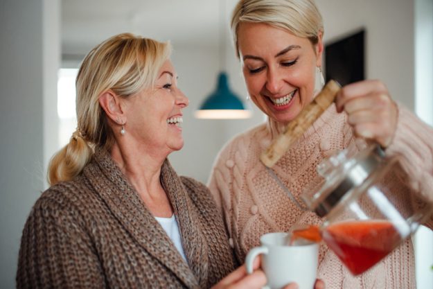A young woman with senior mother at home, pouring tea. Rediscover Life's Joys And Possibilities: Independent Living In Baytown, TX Beckons You
