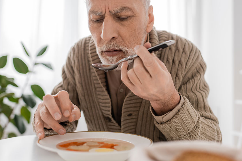 senior bearded man suffering parkinsonism holding spoon trembling hand plate senior bearded man suffering parkinsonism holding spoon trembling hand plate