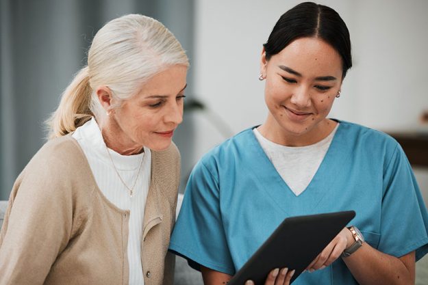 Tablet, news or nurse with old woman consulting after surgery or medical test results Tablet, news or nurse with old woman consulting after surgery or medical test results