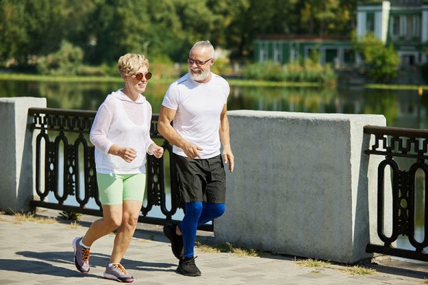 two mature people happy smiling man woman jogging early sunny