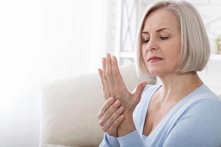 woman massaging her arthritic hand and wrist