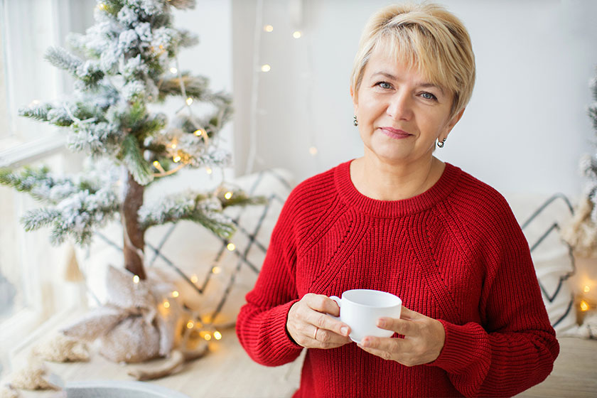 Beautiful smiling mature woman holding a cup