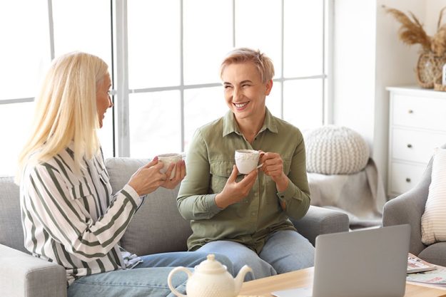 Happy mature women drinking tea home