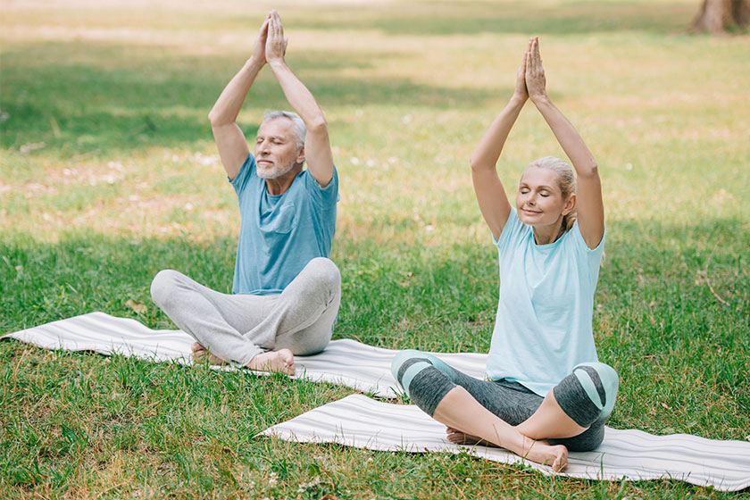 Mature man woman sitting lotus poses meditating park Mature man woman sitting lotus poses meditating park