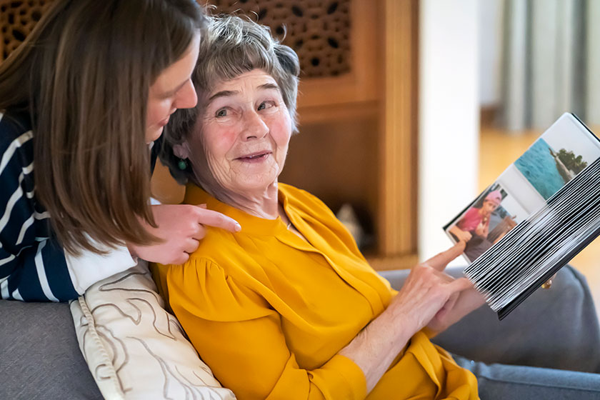 Old woman with her granddaughter look at family photos