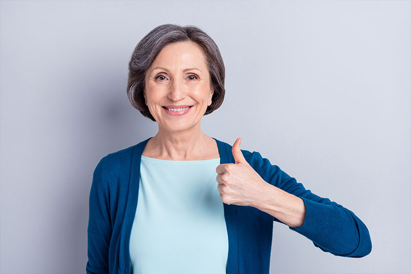 photo of attractive positive old pretty woman show thumb up smile recommend isolated on grey