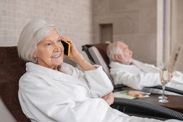 Senior couple in white robes spending a day in spa salon