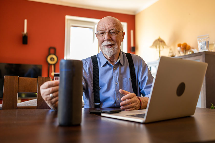Senior man using virtual assistant home