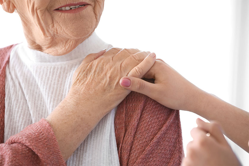 caregiver with senior woman in nursing home closeup