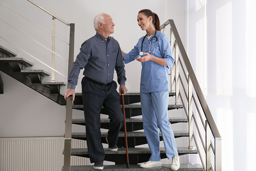Doctor helping senior patient in modern hospital
