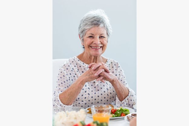 Elderly woman having breakfast